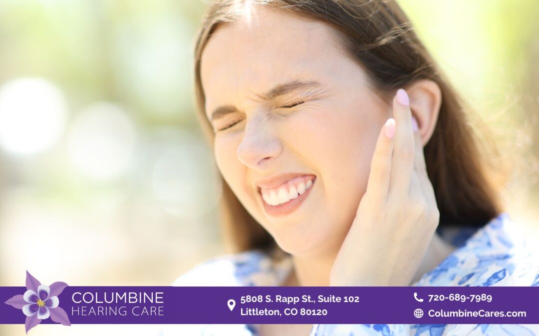 A woman holding her ear closing her eyes.